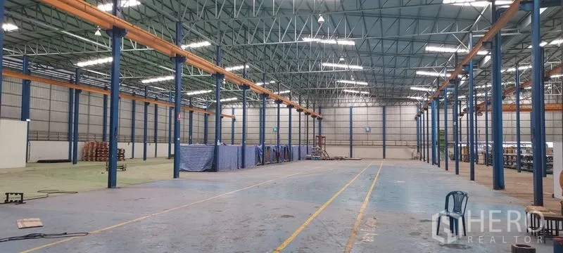 Factory for rent in Phra Pradaeng, Samut Prakan - Vast warehouse hall with high steel truss roof and clear span columns.