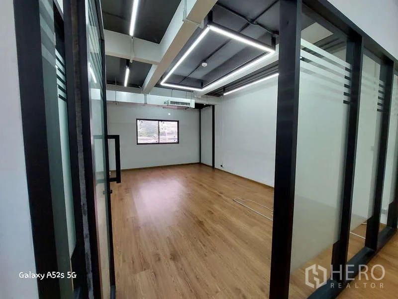 Office Space for rent in Khlong Toei, Bangkok - Glass-walled private office or meeting room with LED ceiling lights and wood flooring.