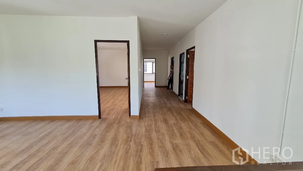 独栋房屋 for rent in Lat Phrao, Bangkok - 二层宽大走廊与起居空间，木地板通往多间房间。