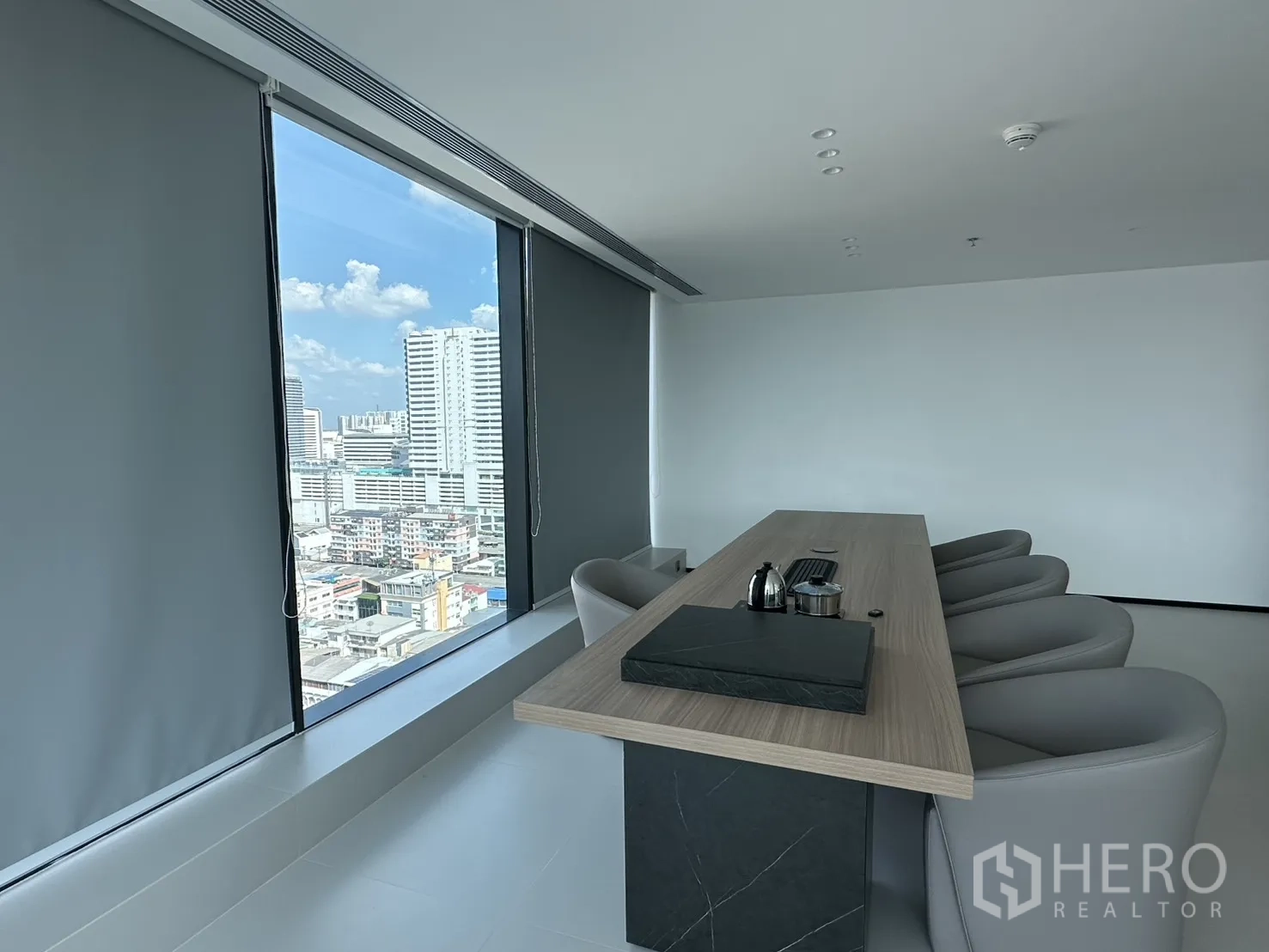 Office Space for rent in Din Daeng, Bangkok - Boardroom with a long table, cushioned chairs, and roller blinds beside large windows.