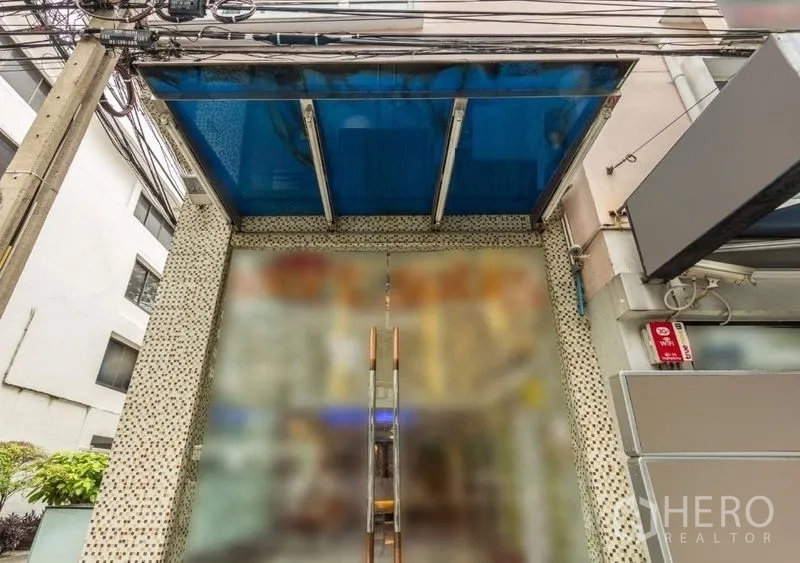 零售空间 出租 - 带蓝色雨棚的玻璃店面入口，双开门，临街位置。