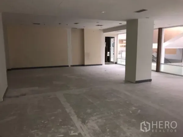 Office Space for rent in Bang Rak, Bangkok - Spacious shell office area with large windows and an entry to the corridor.