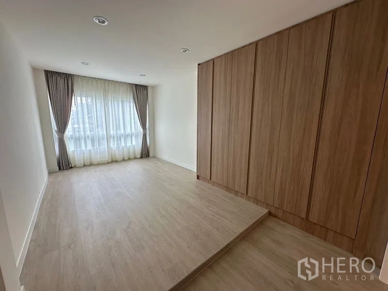Home Office for rent in Khlong Toei, Bangkok - Elevated bedroom area with wall-to-wall wardrobes and sheer drapes.