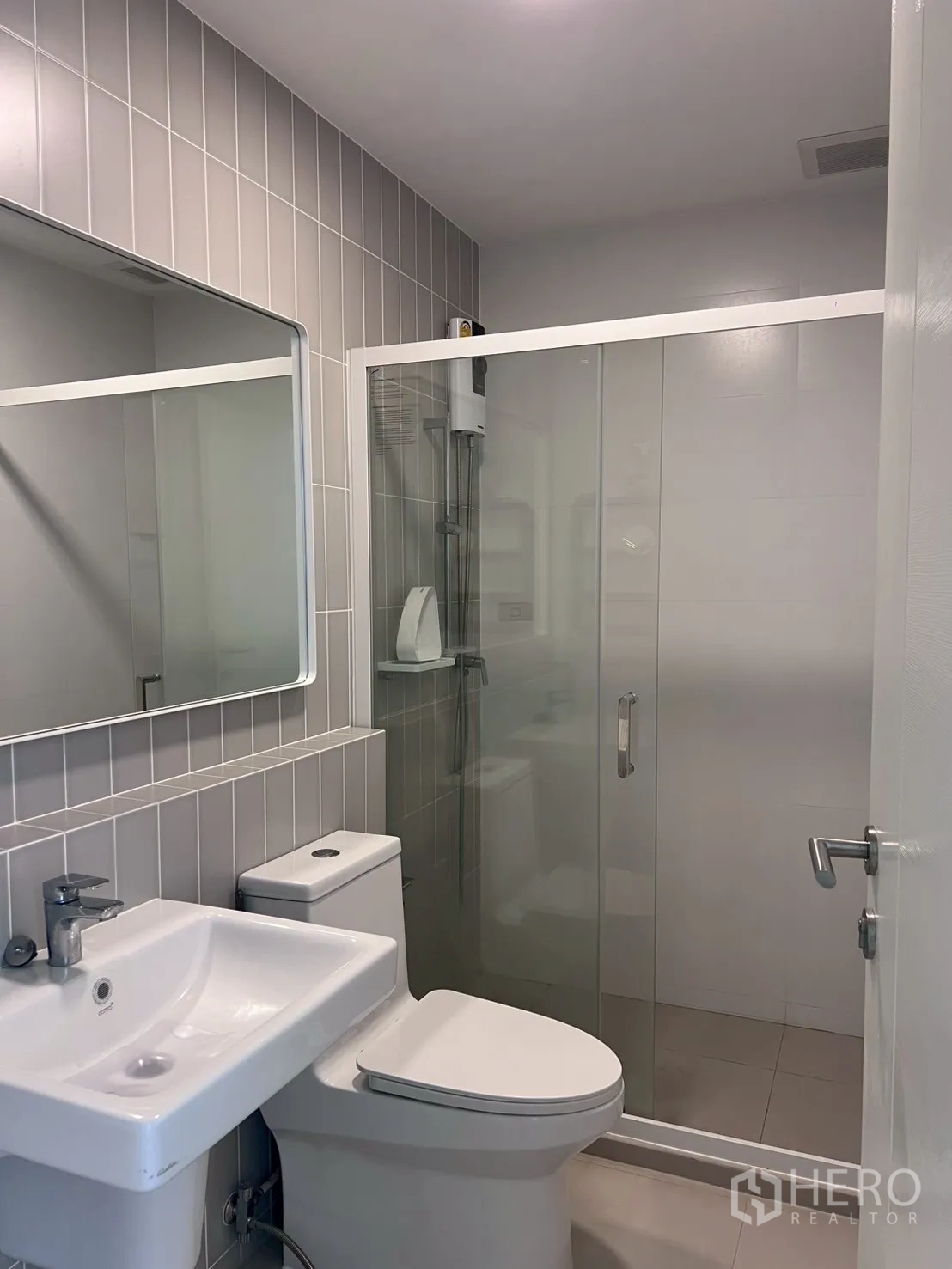 Townhouse for rent in Bang Phli, Samut Prakan - Bathroom with glass-enclosed shower, toilet, and vanity basin.