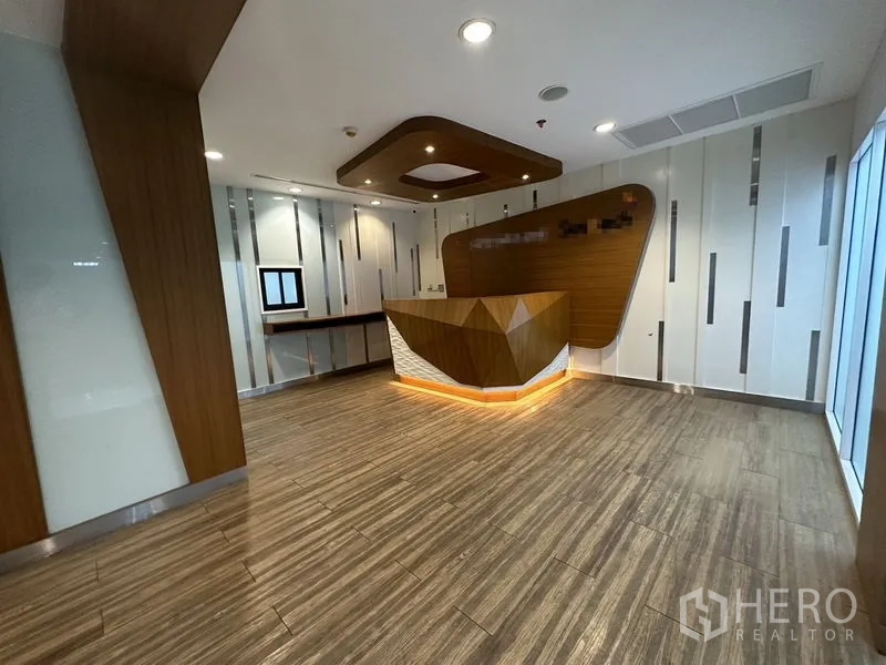 Office Space for rent or sale - Reception lobby with geometric wooden counter and modern ceiling lights.