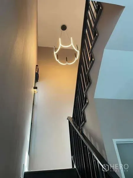 Detached House for rent in Bang Phli, Samut Prakan - Staircase with black metal railing and a contemporary pendant light.