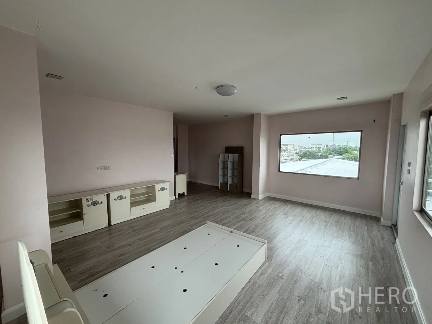 Warehouse for rent or sale in Wang Thonglang, Bangkok - Wide pink bedroom with platform bed base and large window.