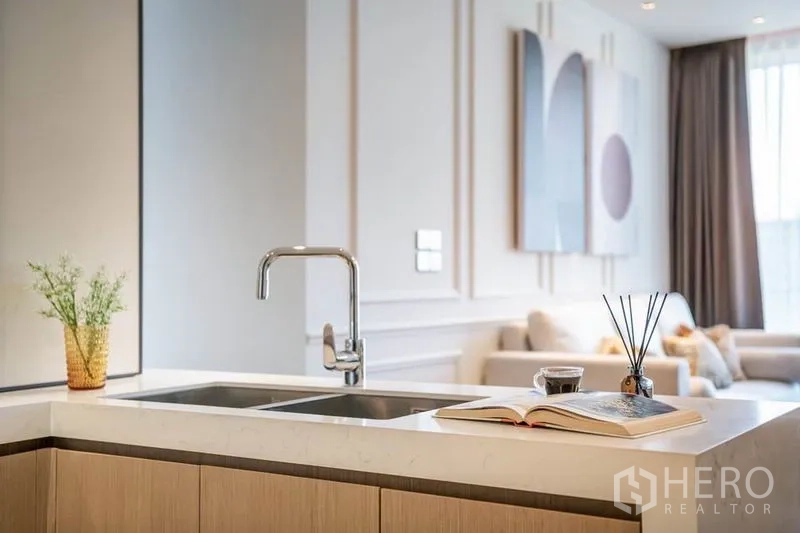 Condominium for rent in Khlong Toei, Bangkok - Modern kitchen island with double sink and quartz countertop.