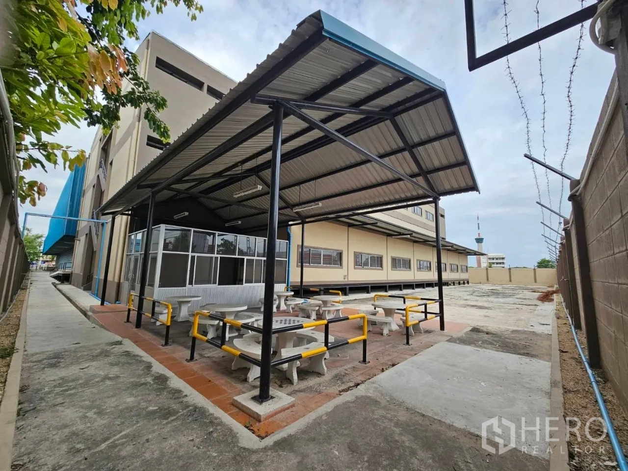 Factory for rent in Si Racha, Chon Buri - Sheltered staff canteen area with benches next to the factory building.