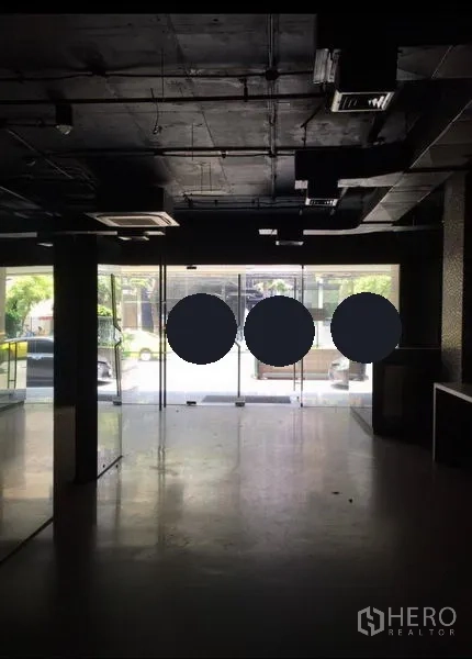 Office Space for rent in Pathum Wan, Bangkok - Open interior facing a floor-to-ceiling glass storefront with exposed black ceiling and ducted AC.