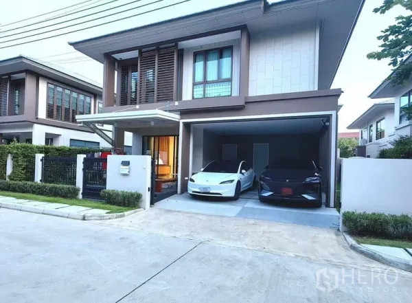 Detached House for rent in Bang Kapi, Bangkok - Modern two-storey detached house facade with covered two-car garage and small garden in a gated estate