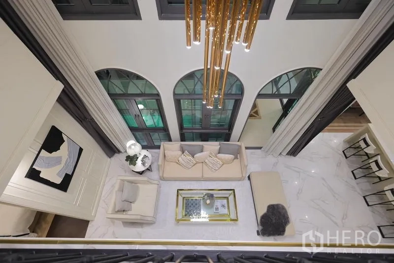 Detached House for rent or sale in Watthana, Bangkok - Top-down view of the living room showcasing chandelier and arched windows.