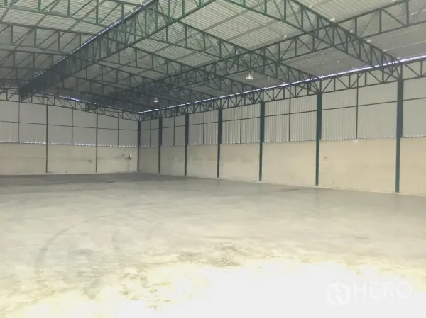 Warehouse for rent in Si Racha, Chon Buri - Open, column-free storage hall with metal cladding walls and overhead lighting.