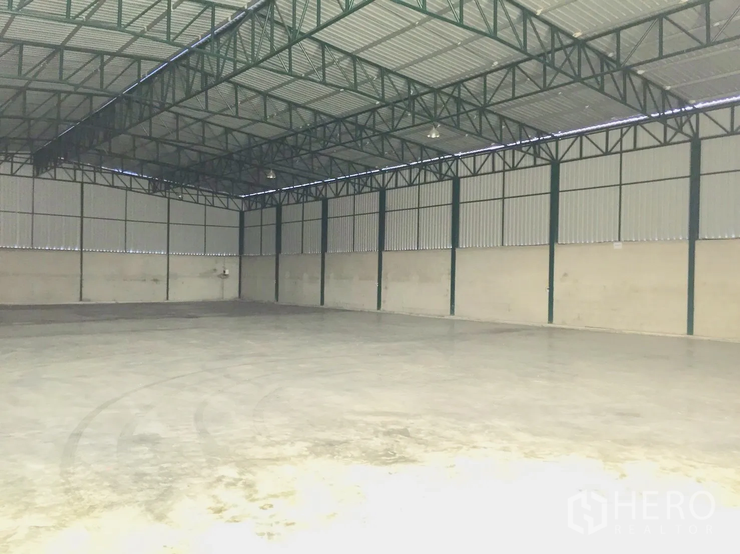 Warehouse for rent in Si Racha, Chon Buri - Open, column-free storage hall with metal cladding walls and overhead lighting.