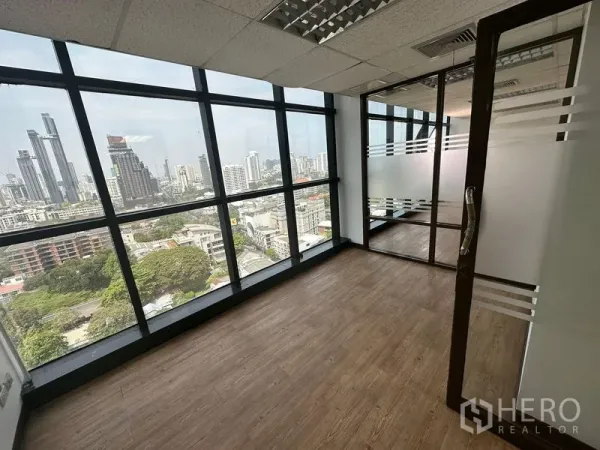 Office Space for rent - Corner meeting room with floor-to-ceiling windows over Bangkok’s skyline and a glass door partition.