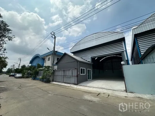 Factory for rent in Pak Kret, Nonthaburi - Corner perspective of the warehouse with a small office annex and wide loading apron.