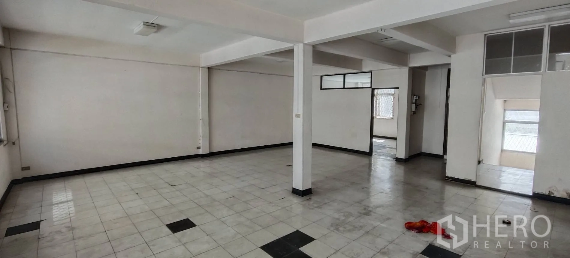 Shophouse for rent in Watthana, Bangkok - Open-plan floor with tiled surfaces and a doorway to the stairwell.