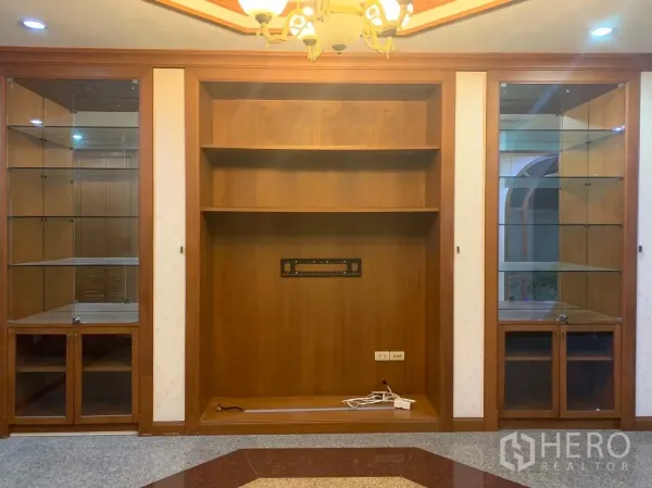 独立式住宅 出租在Watthana, Bangkok - 客厅内置木质电视墙与玻璃展示柜