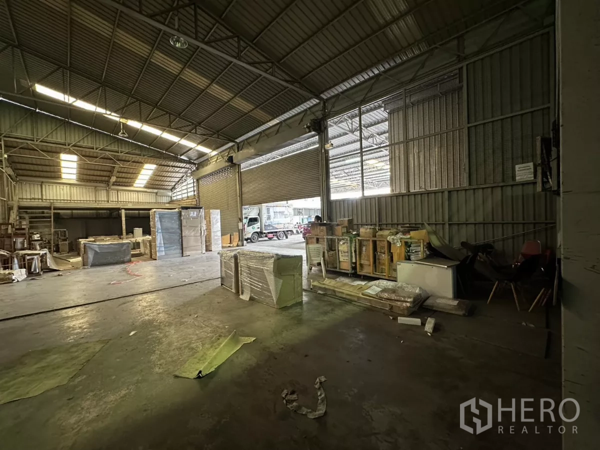 Warehouse for rent in Yan Nawa, Bangkok - Warehouse hall with roller shutter doors open to a loading dock and a truck outside.