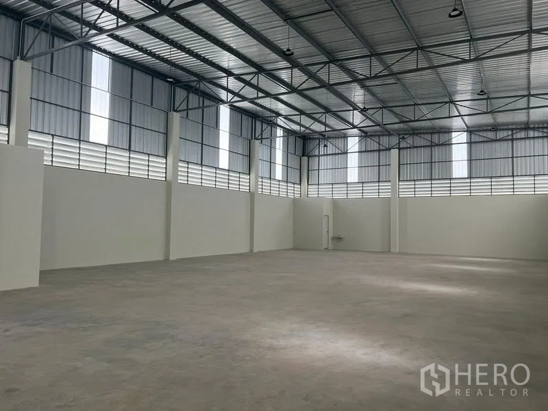 Warehouse for rent in Bang Phli, Samut Prakan - Open storage hall showing tall 7–11 m ceiling, louvered panels for ventilation and bright natural light.