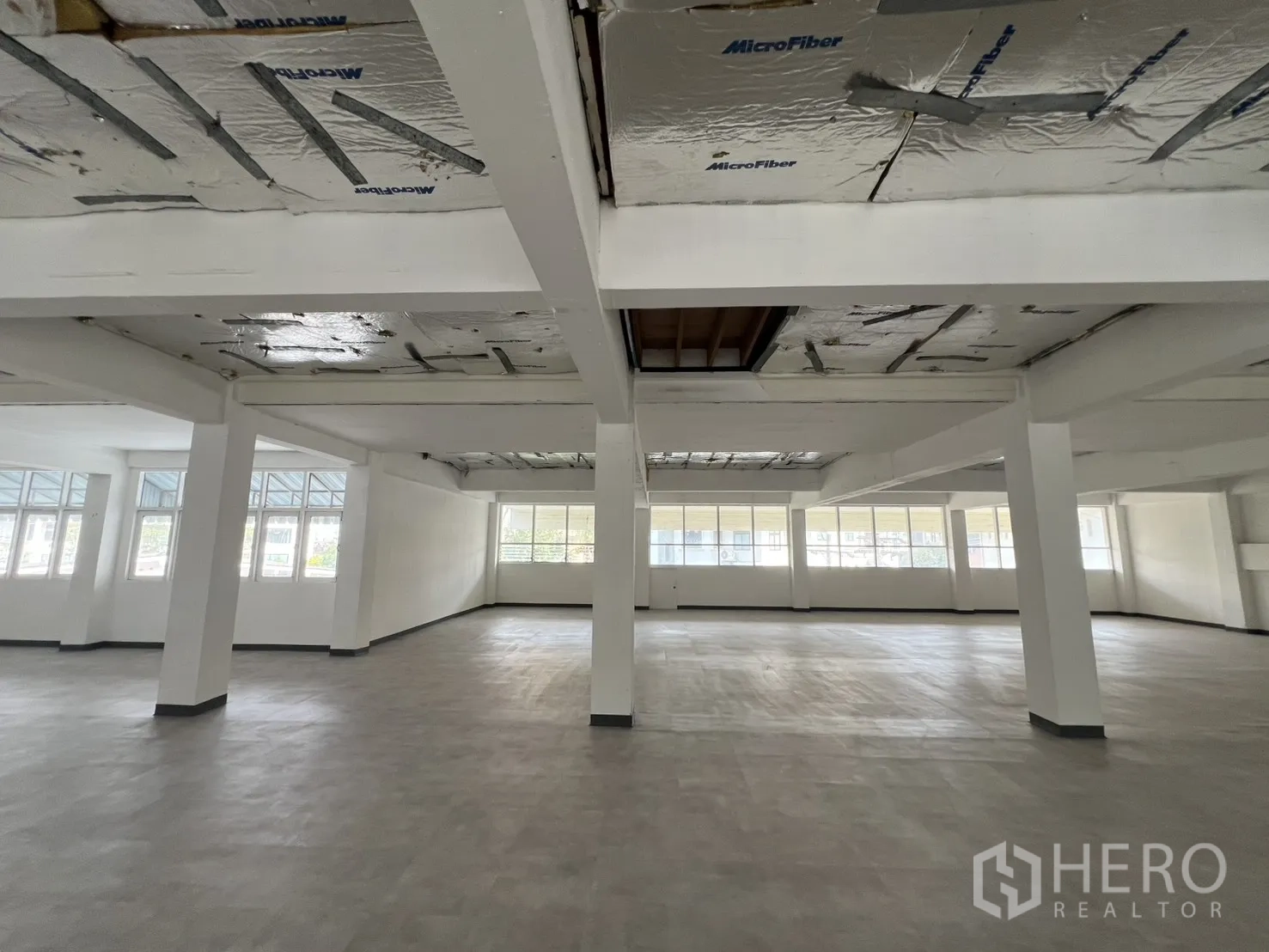 Office Space for rent in Watthana, Bangkok - Open office floor with support beams and corner windows for cross ventilation.