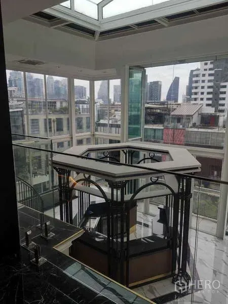 Retail Space for rent - Glass atrium with city views and a central kiosk under a skylight.