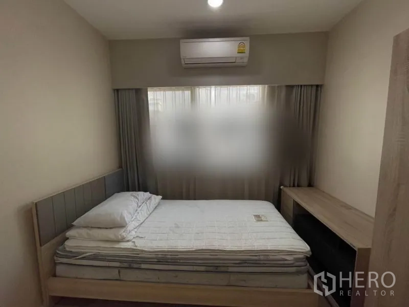 Townhouse for sale in Suan Luang, Bangkok - Cozy bedroom with bed, bedside table, air conditioner and curtained window.
