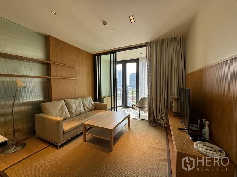 Condominium for rent - Living room opening to a balcony with cityscape beyond, neutral décor and wood paneling.