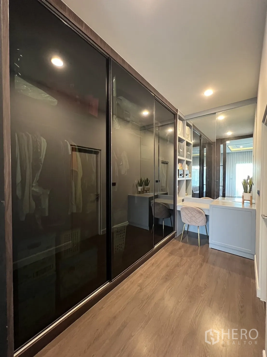 Detached House for rent or sale in Bang Kapi, Bangkok - Walk-in closet with black glass wardrobes and dressing table.
