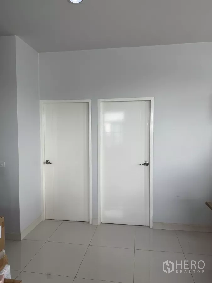 Factory for sale in Lam Luk Ka, Pathum Thani - Two white interior doors in a tiled office area inside the factory.