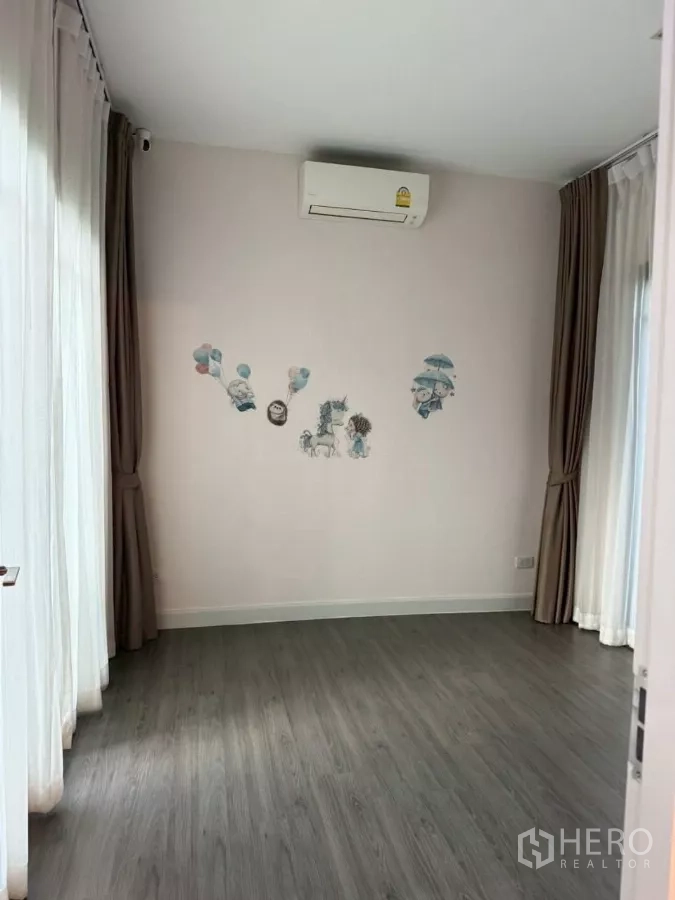Detached House for rent or sale in Bang Phli, Samut Prakan - Bright corner room with air conditioner, playful wall decals and wraparound curtains.