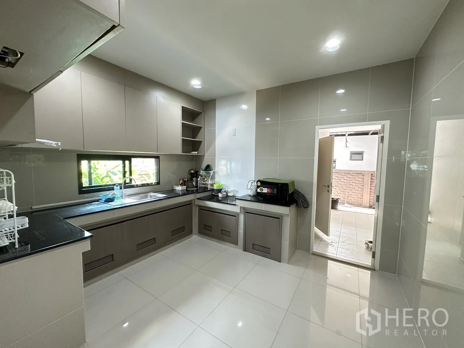 Detached House for rent or sale in Lam Luk Ka, Pathum Thani - Enclosed U-shaped kitchen with ample cabinets and window.