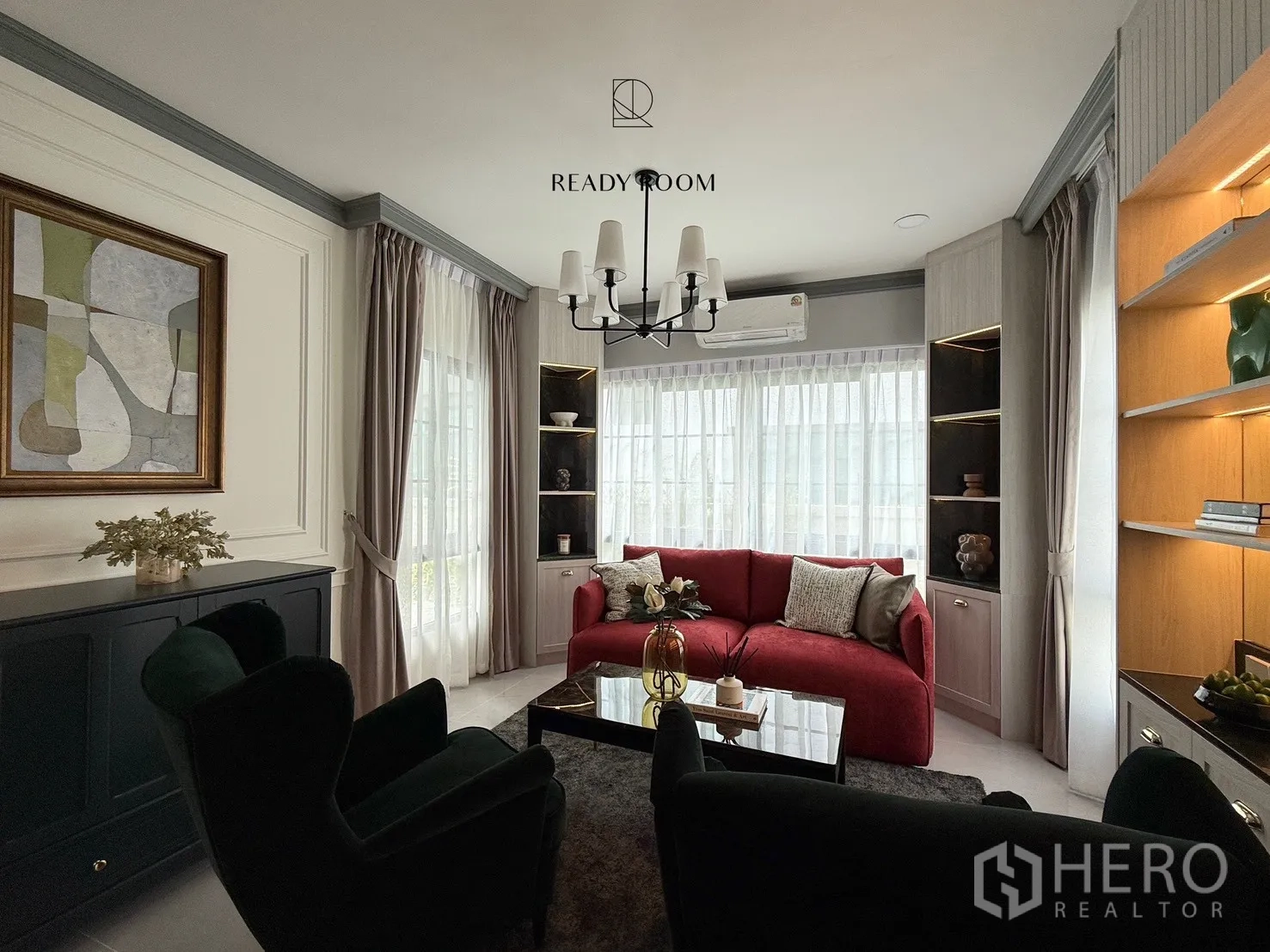 Detached House for rent or sale in Bang Phli, Samut Prakan - Wide view of the lounge with red sectional, illuminated shelving and abstract wall art.