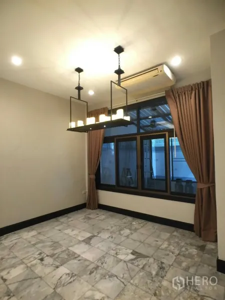 Townhouse for rent in Khlong Toei, Bangkok - Dining area with marble tile floor, large window with curtains, and rectangular pendant chandelier.