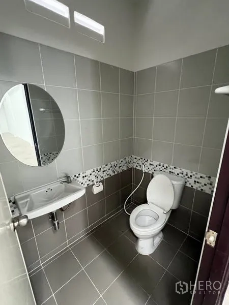 Warehouse for rent in Phra Samut Chedi, Samut Prakan - Tidy tiled bathroom with toilet, sink, mirror and wall vents.