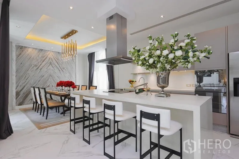 Detached House for rent or sale in Watthana, Bangkok - Kitchen breakfast bar with four stools and view to the dining area.