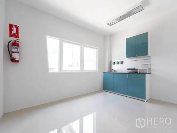 工厂 出租在Bang Bo, Samut Prakan - 茶水间配青绿色橱柜与水槽，带窗户及墙式灭火器