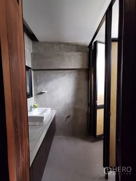 带办公室的家 出售在Wang Thonglang, Bangkok - 小型浴室，清水混凝土墙、台盆与采光门。