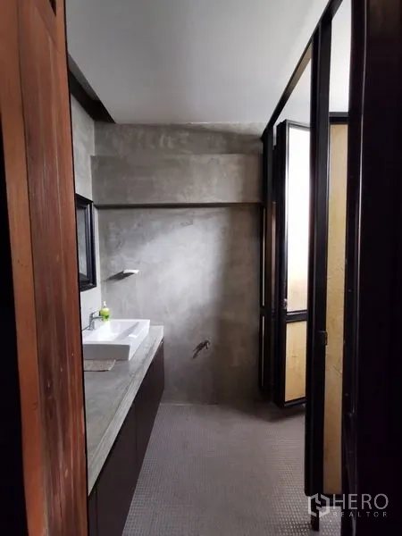 带办公室的家 出售在Wang Thonglang, Bangkok - 小型浴室，清水混凝土墙、台盆与采光门。