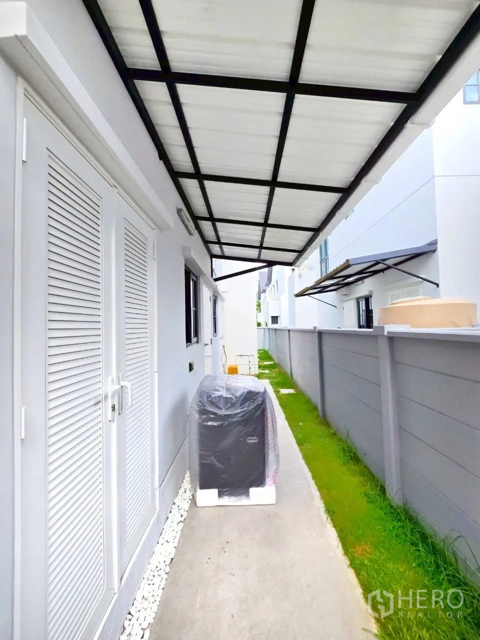 Detached House for rent in Bang Phli, Samut Prakan - Covered side walkway with utility area and lawn beside fence