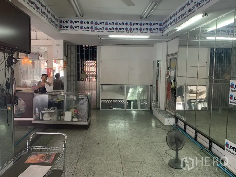 Shophouse for rent in Khlong Toei, Bangkok - Deep shop interior featuring mirrored wall panels, terrazzo flooring and a rear security gate.