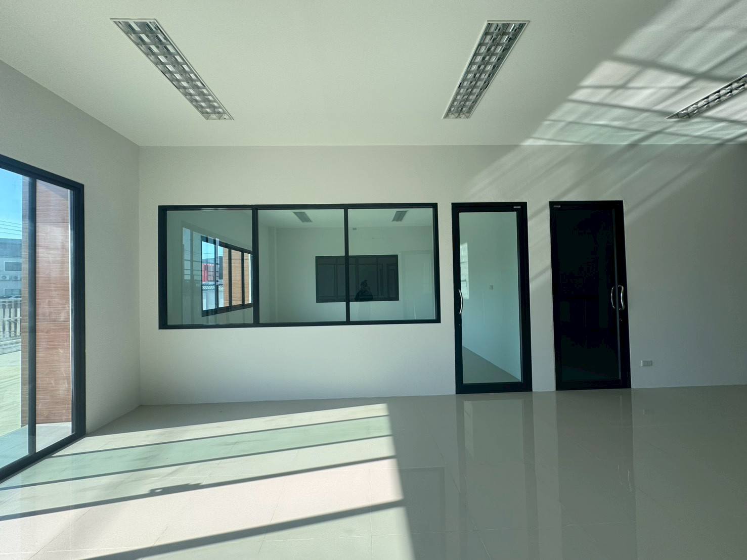 Factory for sale in Mueang Samut Sakhon, Samut Sakhon - Office area with glass partitions, black-framed doors and sliding glass access.
