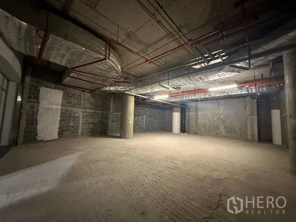 Retail Space for rent - Wide open-plan shop space with rough concrete floor, block walls and insulated ceiling ducts.