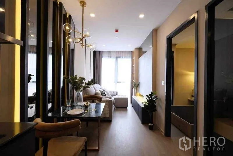 Condominium for rent in Watthana, Bangkok - Hallway view of the living room and dining area with the bedroom entrance on the right.