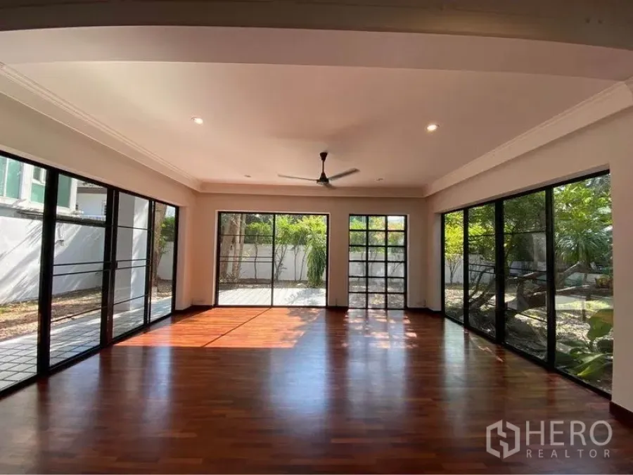 Detached House for rent in Watthana, Bangkok - Sunlit garden-facing room with floor-to-ceiling glass doors.