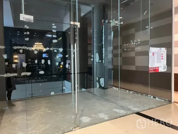 Retail Space for rent in Watthana, Bangkok - Double glass doors opening to an empty 20 sqm shop space facing the interior atrium of a shopping center near BTS Ekkamai.