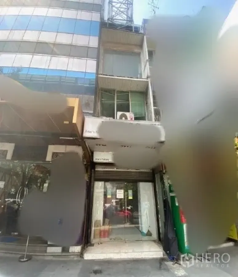 Shophouse for rent in Watthana, Bangkok - Multi-storey shophouse exterior with glass storefront and signage in the Sukhumvit area near BTS Nana.