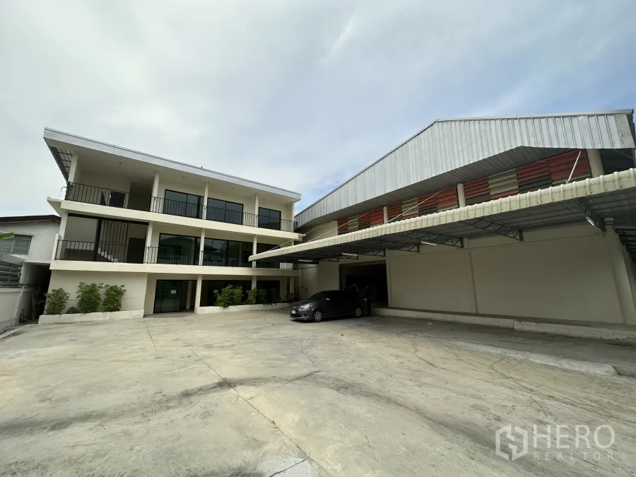 Warehouse for rent in Suan Luang, Bangkok - Spacious concrete yard with three-storey office block and covered loading bay at a Suan Luang warehouse.