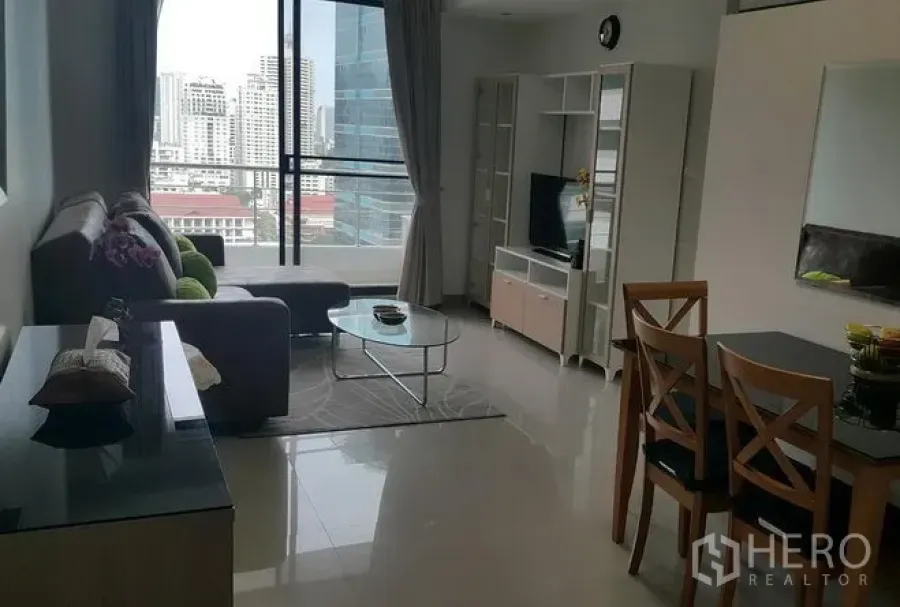 Condominium for rent in Watthana, Bangkok - Bright living and dining area with large windows and a city skyline view in a modern Bangkok condo.