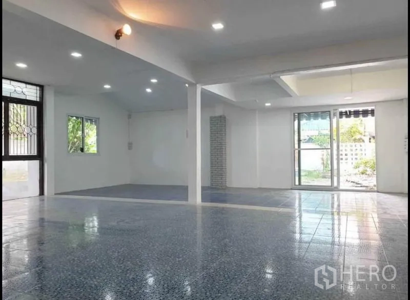 Detached House for rent in Lat Phrao, Bangkok - Large open hall with LED downlights, patterned tile floors and sliding doors to the garden area.
